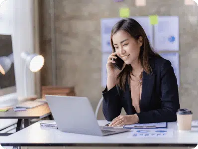 Una ragazza al telefono che usa il suo computer portatile